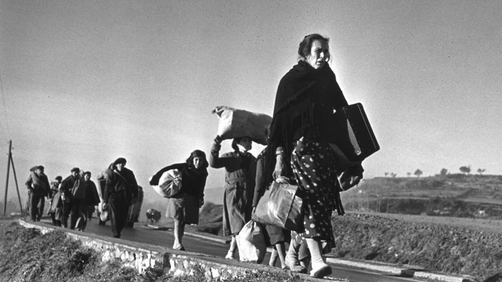 Exiliados de España caminando. Fotografía en blanco y negro.